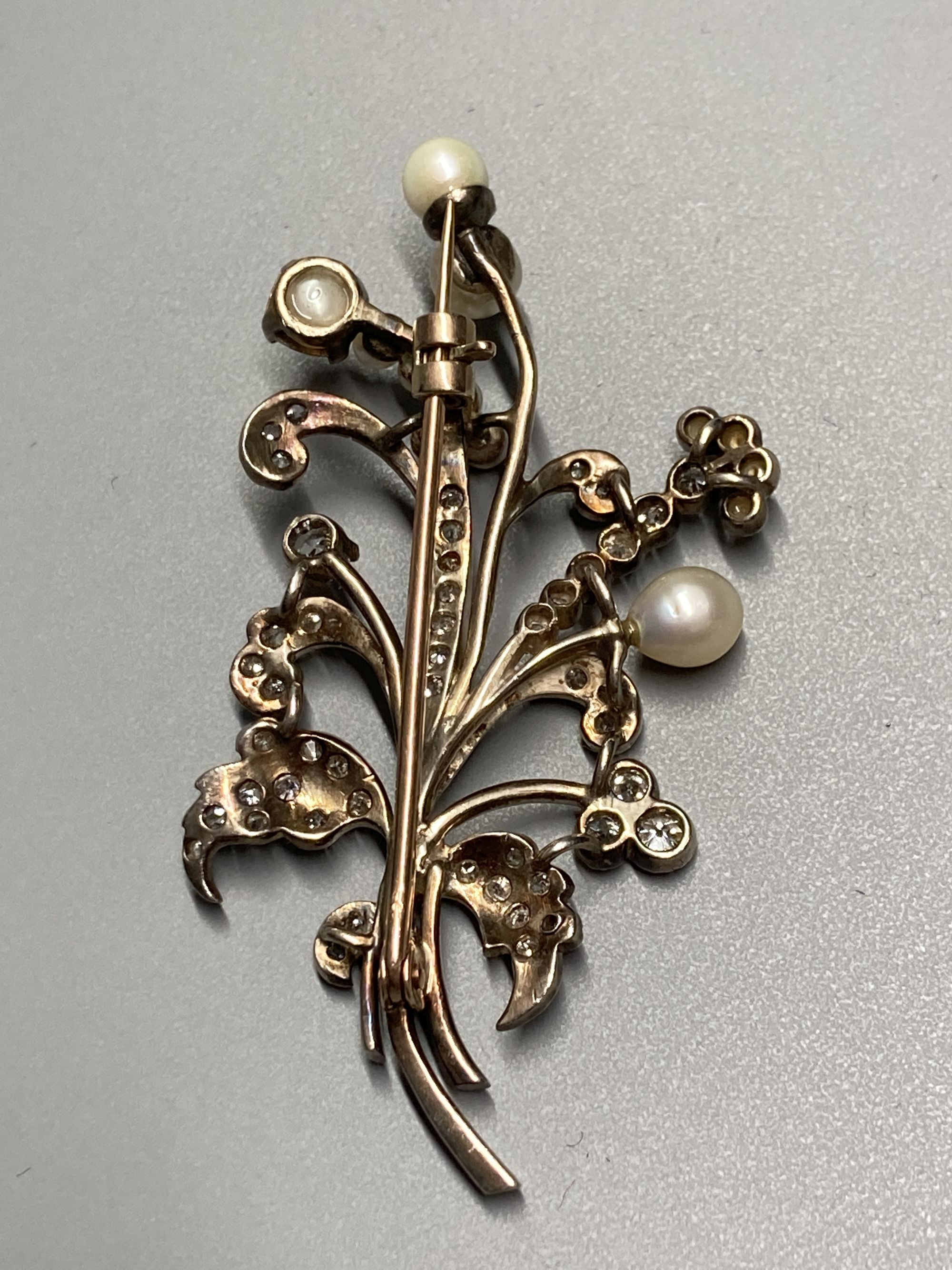 An early 20th century yellow and white metal, cultured pearl and diamond set floral spray brooch, 6cm, gross 12.6 grams.